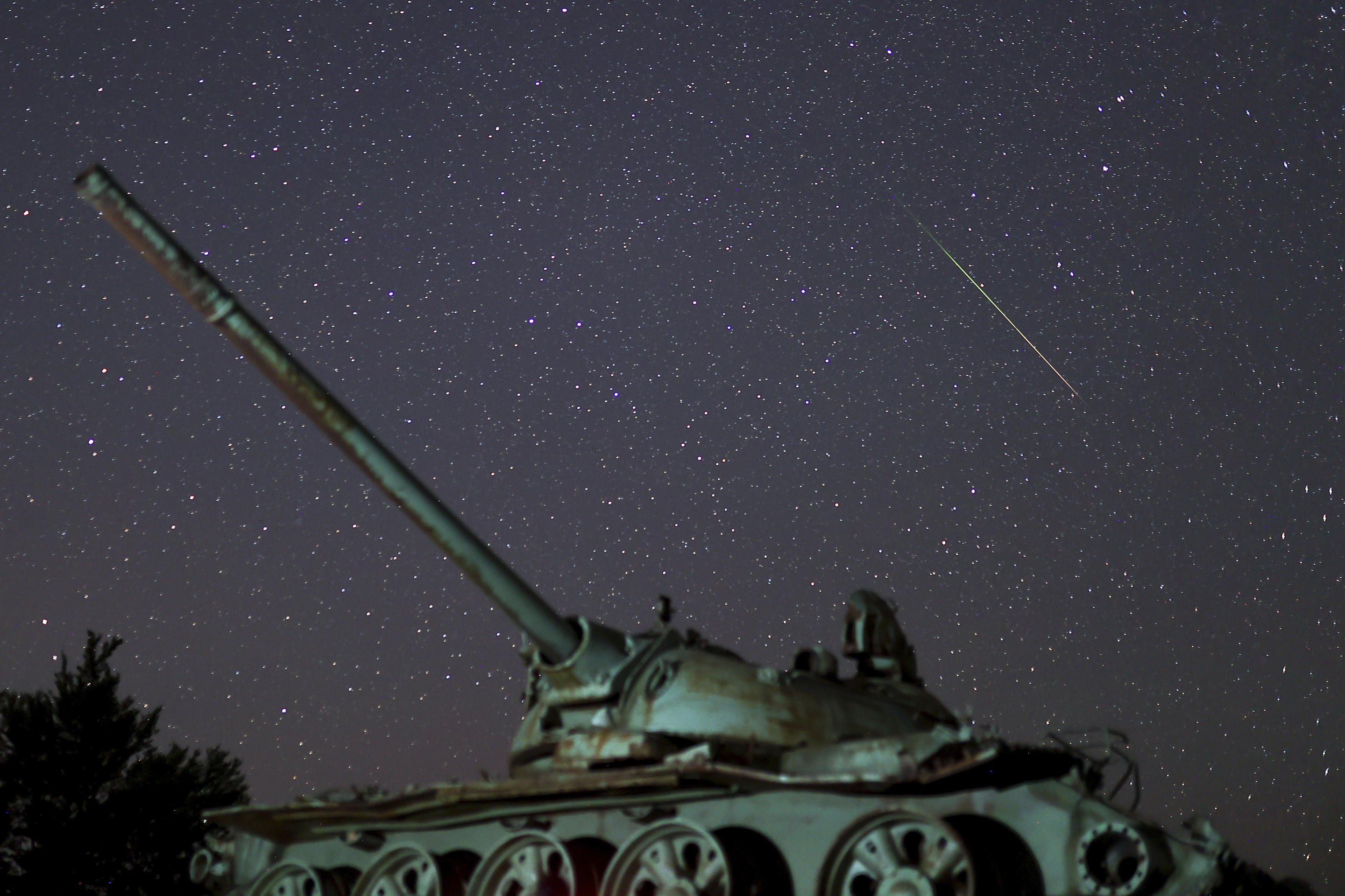 A meteor streaks across the sky above a destroyed tank left on Bjelasnica mountain following the war in Bosnia. 