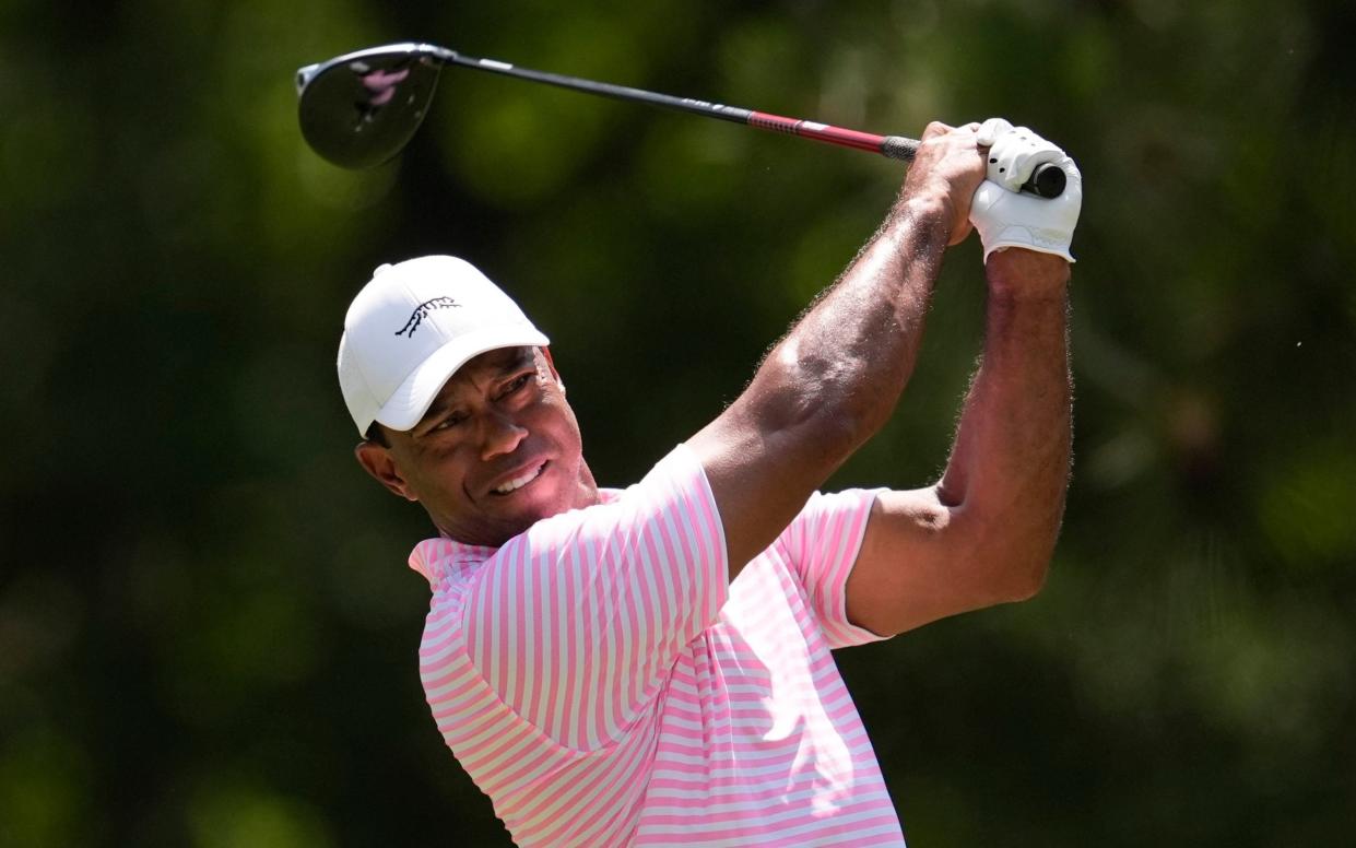 Tiger Woods watches his tee shot on the fifth hole during the first round