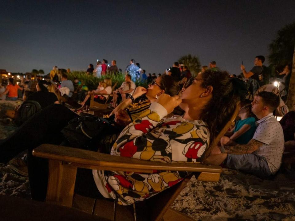 crowd of people watching the magic kingdom fireworks from the polynesian resort disney world