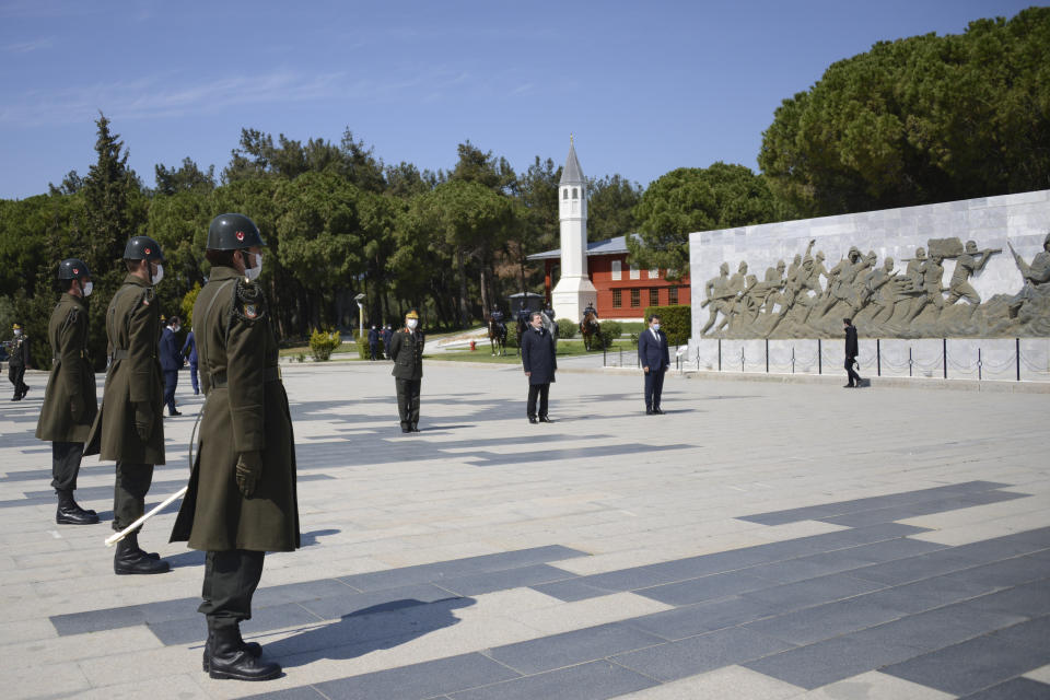 In this Friday, April 24, 2020, photo provided by the Canakkale Governorate, few Turkish officials stand in respect at Turkish monument during the commemoration ceremonies marking 105th anniversary of the Gallipoli Campaign, in Canakkale, Turkey. Traditional mass celebrations on the ANZAC Day by Turks, Australians, New Zealanders, British and French have been cancelled due to novel coronavirus this year.(Kadir Oztecik/Canakkale Governorate via AP)