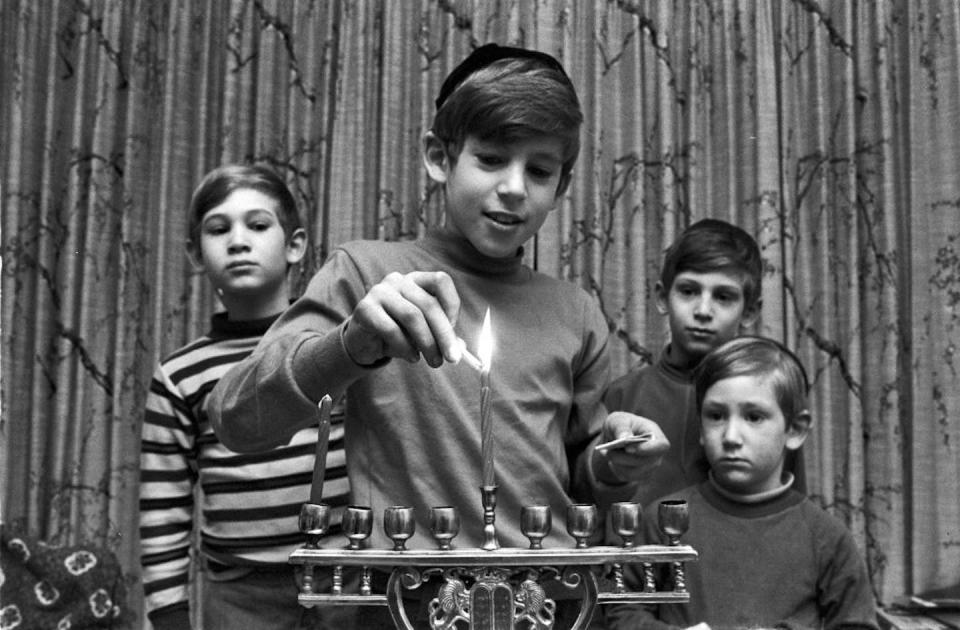 The four sons of a Jewish family in Brookline, Mass., light the first candle of their menorah during Hanukkah in 1971. <a href="https://www.gettyimages.com/detail/news-photo/the-four-sons-of-a-jewish-family-light-a-menorah-during-news-photo/138778964?adppopup=true" rel="nofollow noopener" target="_blank" data-ylk="slk:Spencer Grant/Getty Images;elm:context_link;itc:0;sec:content-canvas" class="link ">Spencer Grant/Getty Images</a>