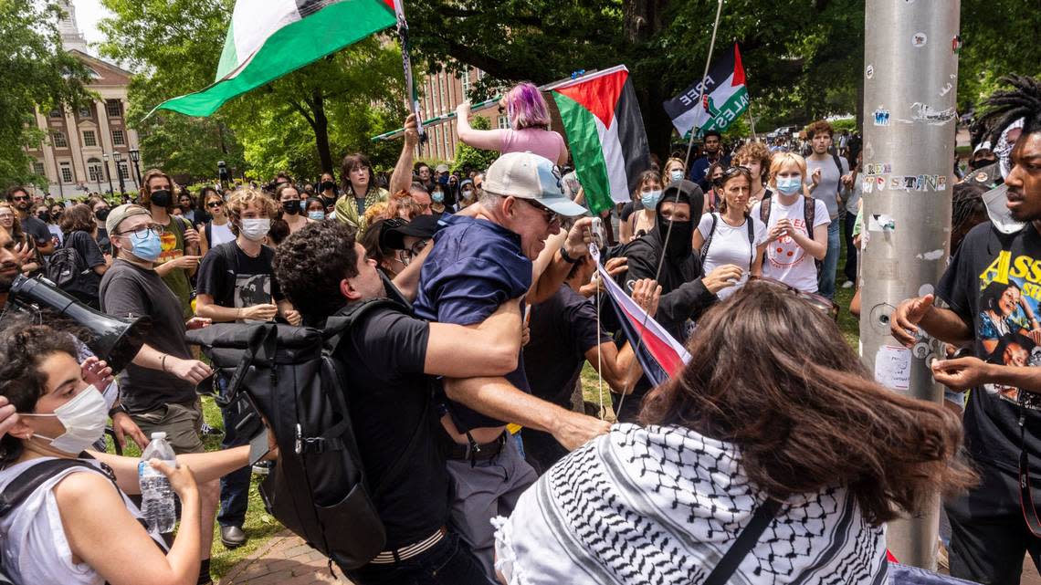 Pro-Palestinian demonstrators struggle with a counter-protester as Pro-Palestinian demonstrators replace an American flag with a Palestinian flag Tuesday, April 30, 2024 at UNC-Chapel Hill. Police removed a “Gaza solidarity encampment” earlier Tuesday morning.