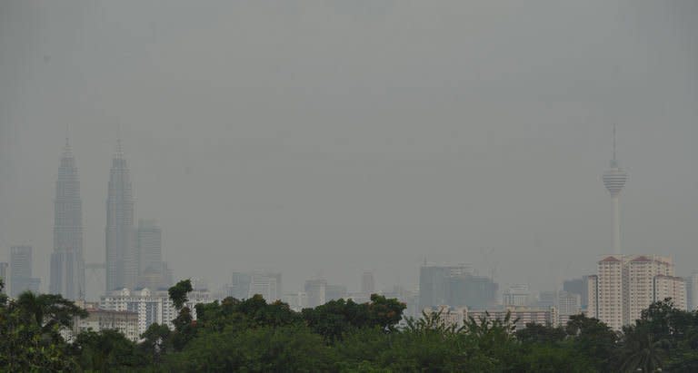 Haze covers Petronas Twin Towers (L) and KL Tower (R) in Kuala Lumpur, on June 16, 2013