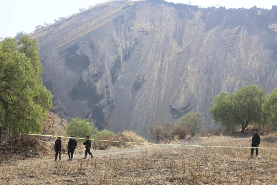 Police stand guard in an area where volunteers said they found a clandestine crematorium in Tlahuac, on the edge of Mexico City, Wednesday, May 1, 2024. Ceci Flores, a leader of one of the groups of so-called "searching mothers" from northern Mexico, announced late Tuesday that her team had found bones around clandestine burial pits and ID cards, and prosecutors said they were investigating to determine the nature of the remains found. (AP Photo/Ginnette Riquelme)