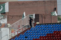 A Pakistani police officer stands guard an enclosure in the Pindi Cricket Stadium before the start of the first one day international cricket match between Pakistan and New Zealand, in Rawalpindi, Pakistan, Friday, Sept. 17, 2021. The limited-overs series between Pakistan and New Zealand has been postponed due to security concerns of the Kiwis. (AP Photo/Anjum Naveed)