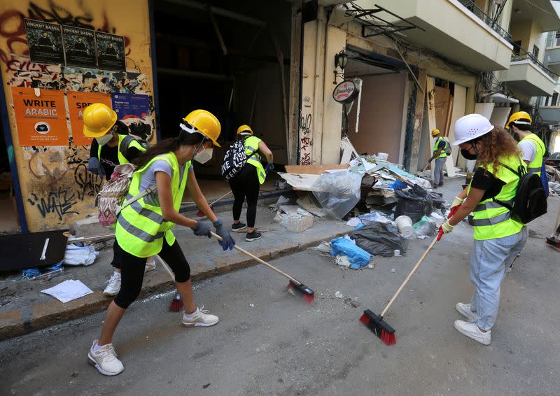 Volunteers clean debris from the street following Tuesday's blast in Beirut's port area