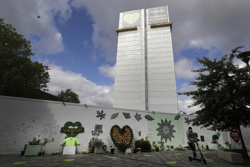 Tributes are placed near Grenfell Tower in London, Sunday, June 14, 2020. Britain is marking the third anniversary of the Grenfell Tower fire with a virtual church service to remember the 72 people who died in the blaze. Sunday marks three years since a small kitchen fire in the west London public-housing block turned into the worst domestic blaze in the country since World War II. (AP Photo/Kirsty Wigglesworth)