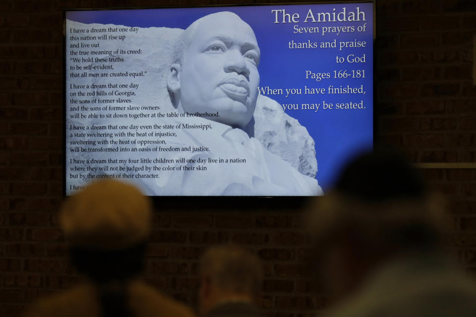 In this Jan. 17, 2020, photo Screen of honoring the Legacy of Rev. Dr. Martin Luther King Jr., during the Friday Shabbat Service at KAM Isaiah Israel in Chicago. On the eve of the day set aside to honor an African American who strove against hate and preached racial and social justice, some worry the nation is becoming more divided. (AP Photo/Nam Y. Huh)