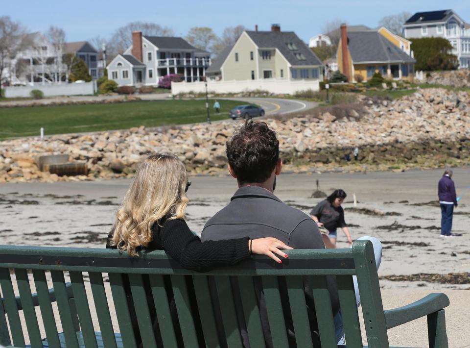 A couple sits on a bench overlooking York's Short Sands Beach on a beautiful Friday afternoon.