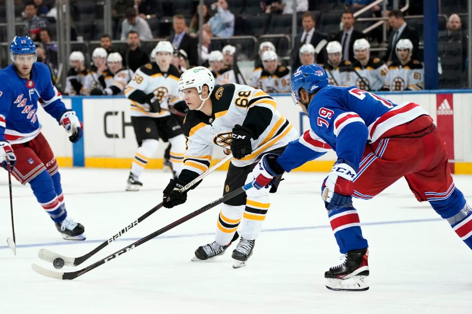 Boston Bruins' Fabian Lysell (68) looks to pass around New York Rangers' K'Andre Miller (79) during the third period of a preseason NHL hockey game, Tuesday, Sept. 28, 2021, at Madison Square Garden in New York. (AP Photo/Corey Sipkin).