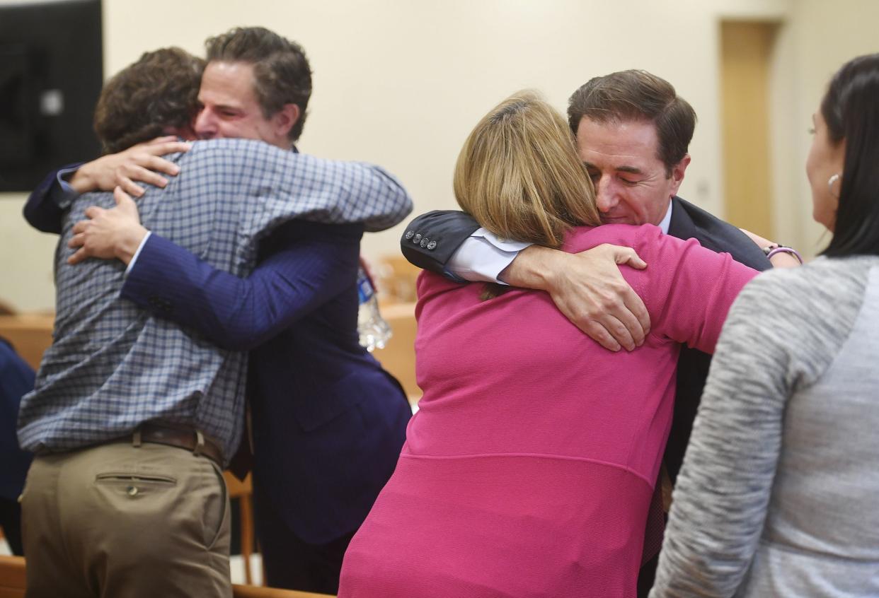 Plaintiff William Sherlach, left, hugs attorney Josh Koskoff while plaintiff Nicole Hockley hugs attorney Chris Mattei following the jury verdict and reading of monetary damages in the Alex Jones defamation trial at Superior Court, Wednesday, Oct. 12, 2022, in Waterbury, Conn.