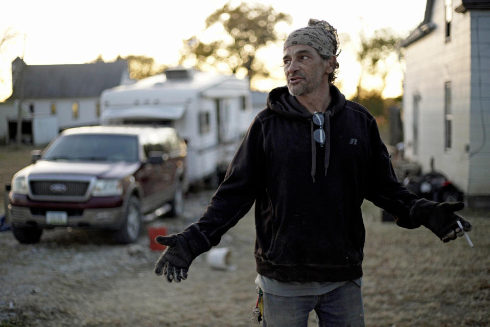 In this Tuesday, Oct. 22, 2019 photo, Marty Study gestures in Bartlett, Iowa, in front of the trailer he has lived in since the March floods. Study said he was rescued from his home, right rear, after floodwaters reached the second floor. Flooding along the Missouri River has stretched on for seven months in places and could endure through the winter, leaving some Upper Midwest farmland and possibly some homes encased in ice. (AP Photo/Nati Harnik)