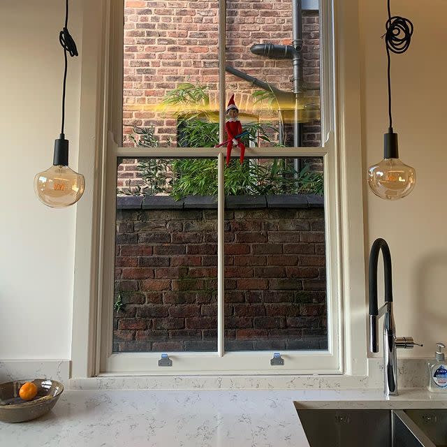 47) Elf on the Shelf perching on the window frame