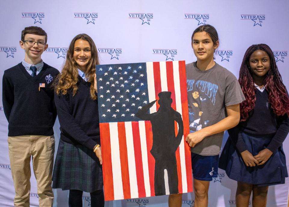 Venerini Academy students Dylan Provencher, Marielle Phillips, Leonardo Zaron, and Kaitlyn Kamuzora donate a painting to Veterans Inc. Thursday.