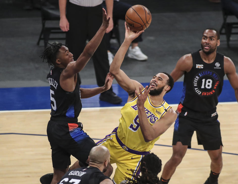 Los Angeles Lakers guard Talen Horton-Tucker, center, shoots over New York Knicks guard Immanuel Quickley, left, in the first quarter of an NBA basketball game at Madison Square Garden in New York, Monday, April 12, 2021. (Wendell Cruz/Pool Photo via AP)