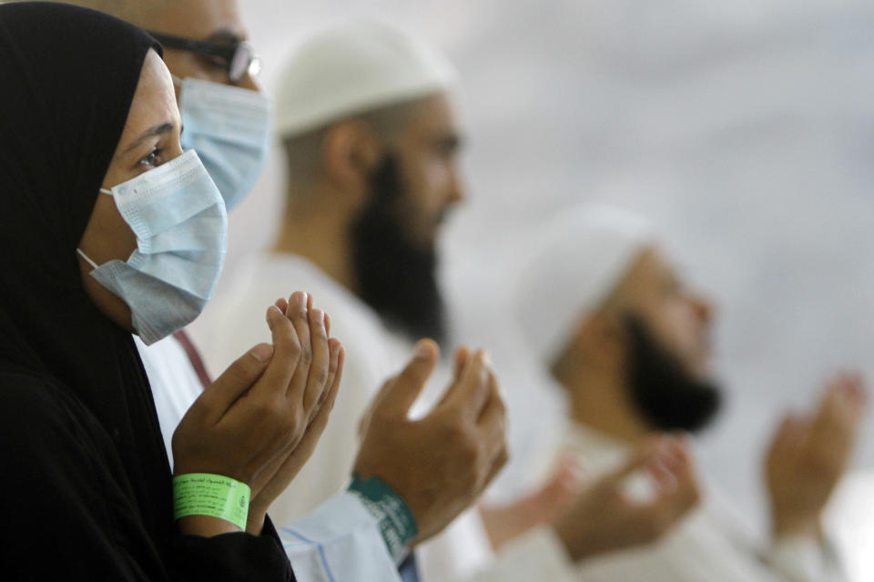 FILE - In this Thursday, Oct. 17, 2013, file photo, Egyptian Muslim pilgrims, some wearing masks as a precaution against the Middle East respiratory syndrome, pray after they cast stones at a pillar, symbolizing the stoning of Satan, in a ritual called "Jamarat," the last rite of the annual hajj, in Mina near the Muslim holy city of Mecca, Saudi Arabia. Saudi Arabia’s King Abdullah sacked the country’s health minister on Monday, April 21, 2014, amid a spike in deaths and infections from the virus known as the Middle East respiratory syndrome, or MERS. The official Saudi Press Agency carried the royal order that said Abdullah al-Rabiah was relieved of his post as Health Minister, and that Labor Minister Adel Faqih will temporarily take over the health minister’s portfolio until a replacement is named. The statement said al-Rabiah is now adviser to the Royal Court. (AP Photo/Amr Nabil, File)