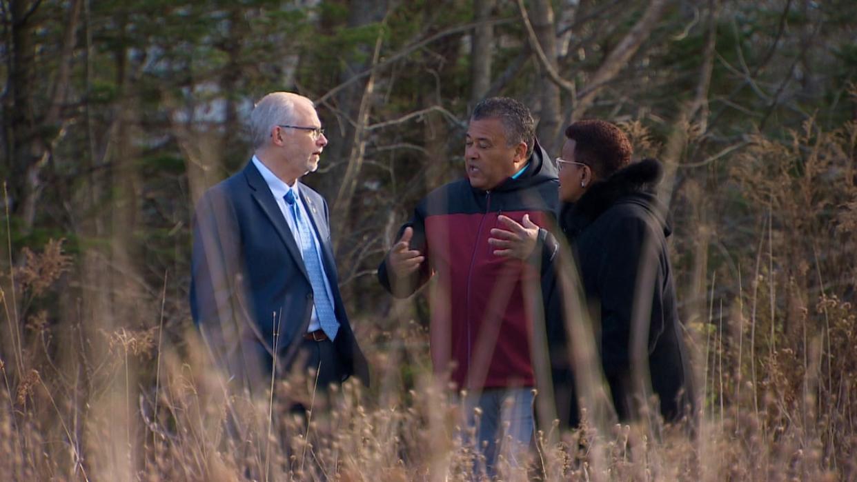 Justice Minister Brad Johns and African Nova Scotian Affairs Minister Twila Grosse walk through land in Cole Harbour earmarked for housing. (David Laughlin/CBC - image credit)