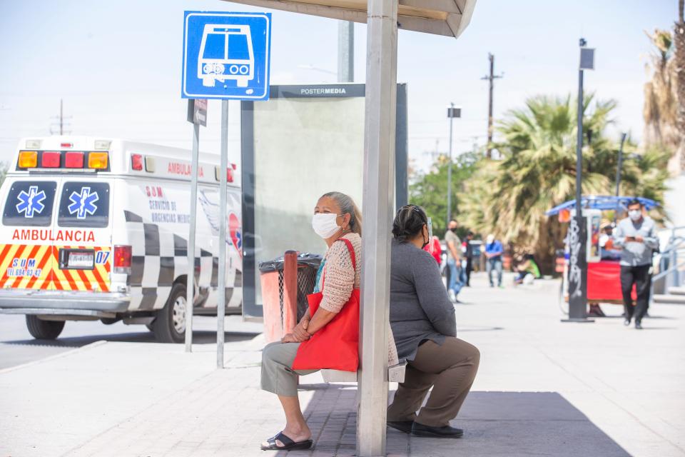 Women wait for public transportation outside Ciudad Juarez's General Hospital on April 27, 2021. The city has seen a spike in COVID-19 infections requiring the city to partially close businesses during the weekends.