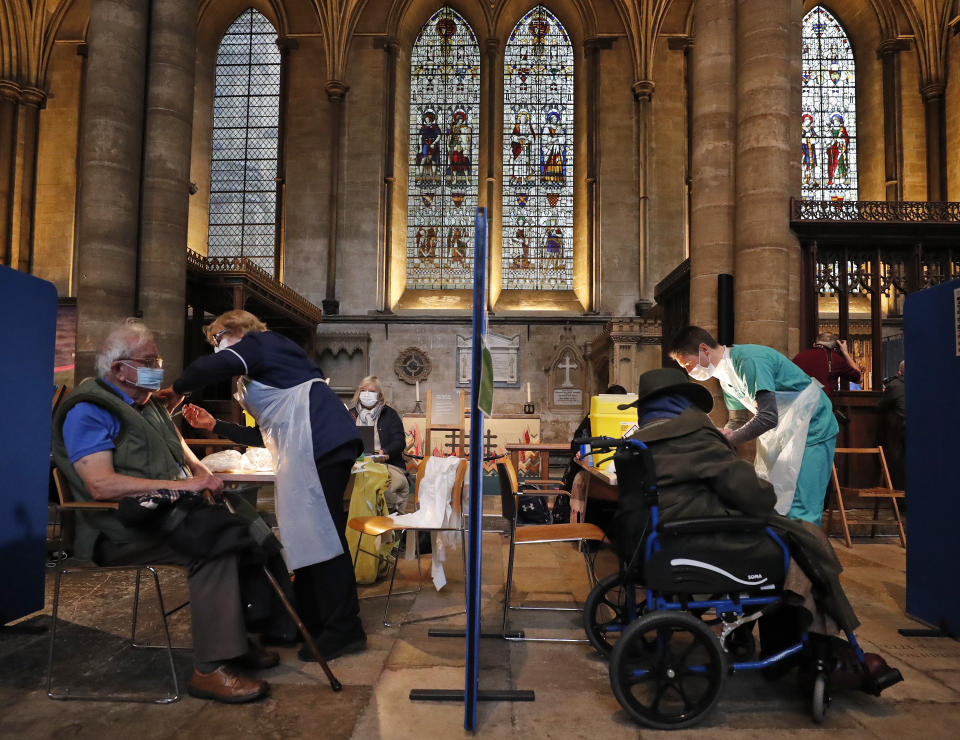 People recieve their Pfizer-BioNTech vaccination inside Salisbury Cathedral in Salisbury, England, Wednesday, Jan. 20, 2021. Salisbury Cathedral opened its doors for the second time as a venue for the Sarum South Primary Care Network COVID-19 Local Vaccination Service. (AP Photo/Frank Augstein)