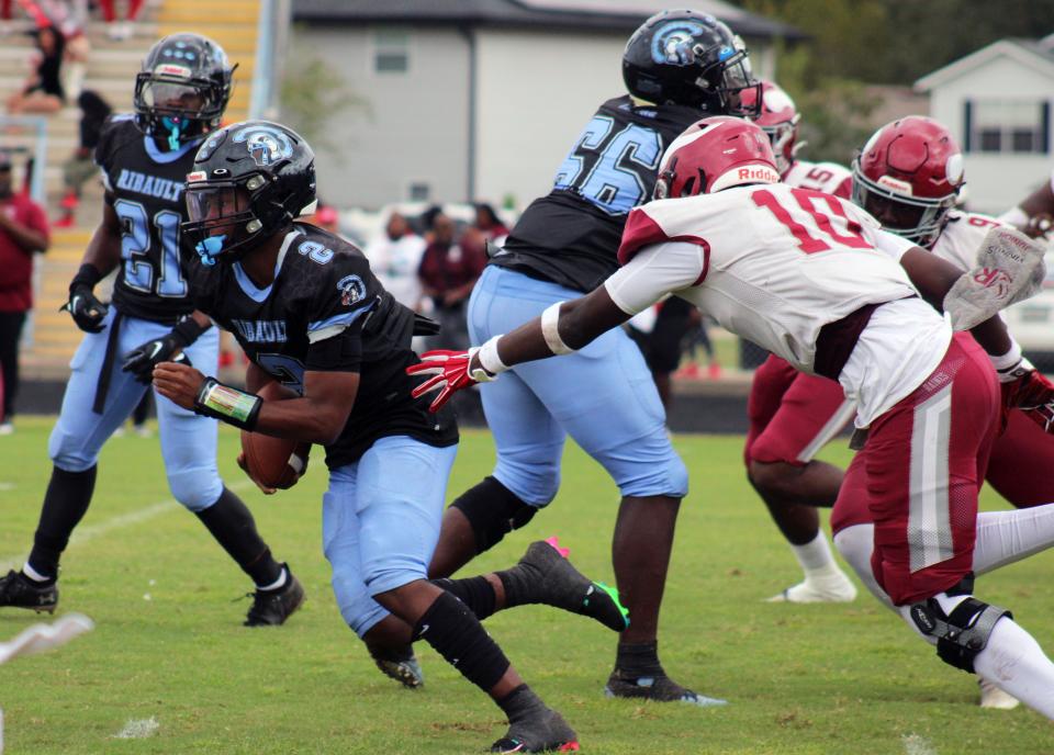Ribault quarterback T.J. Cole (2) runs through a hole as Raines linebacker Terrence Forbes (10) pursues during the Northwest Classic.