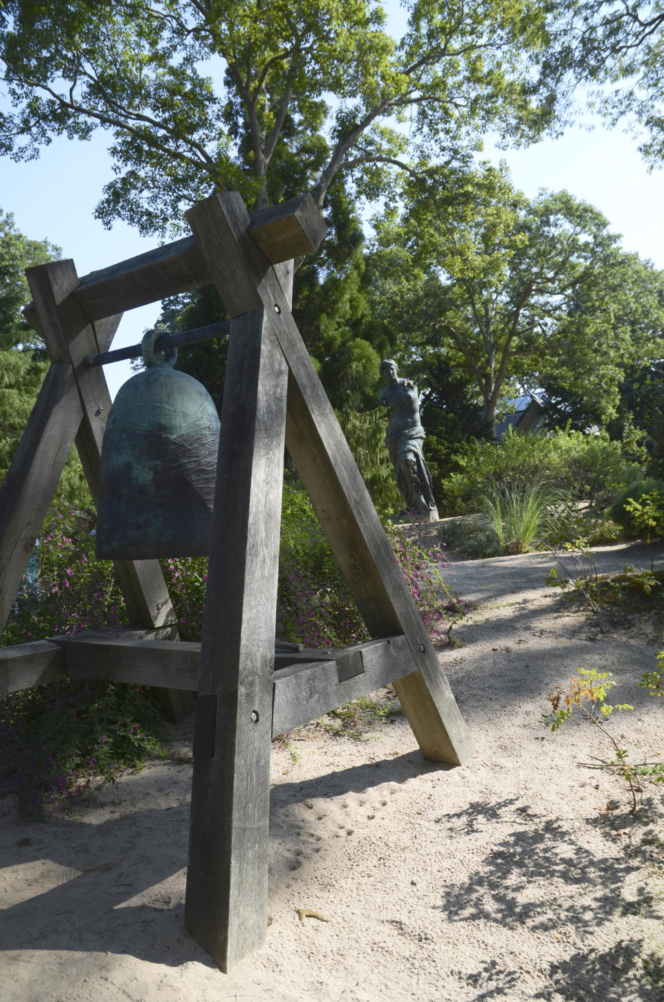 Toshiko Takaezu's "The Gateway Bell," 1993, bronze with wood construction, stands in the Dunes at LongHouse Reserve, Friday, Sept. 16, 2022, in East Hampton, N.Y. The 16-acre sculpture garden, museum and nature reserve was founded by the late textile designer and collector Jack Lenor Larsen. (AP Photo/Pamela Hassell)