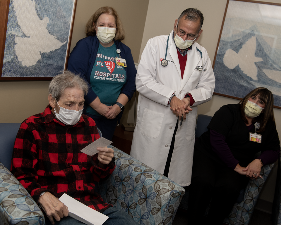 Kent resident Carl Fike opens the envelope containing a $500 check from a Kent Police Department initiative to raise money for local cancer patients. Also in the photo, from left, are registered nurse Laura Vargo, Dr. Saif Rehman and social worker Andrea Miller.