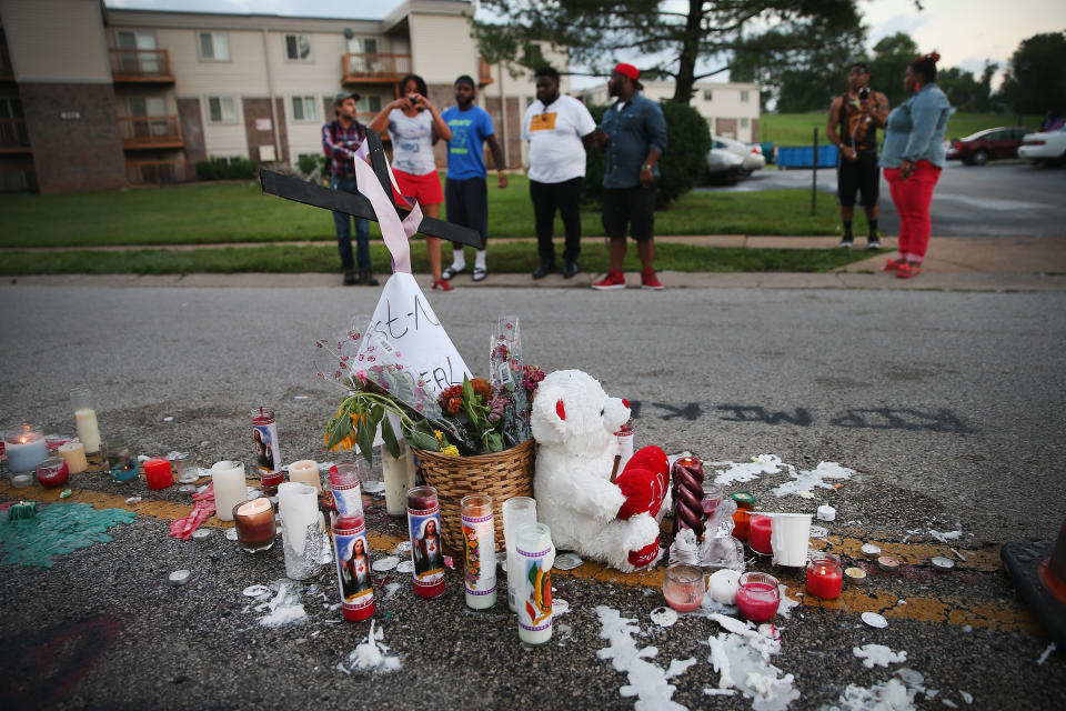 People view a memorial in the street where Michael Brown was shot by police two days earlier.