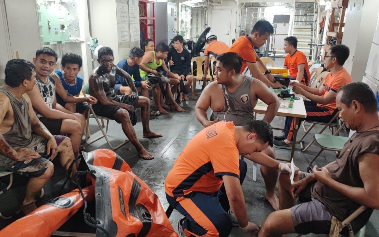 The rescued crew of an oil tanker on a patrol ship off Manila Bay