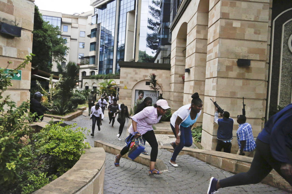 FILE - In this Jan. 15, 2019 file photo, people flee as security forces aim their weapons during a deadly attack by extremists at a luxury hotel complex in Nairobi, Kenya. These African stories captured the world's attention in 2019 - and look to influence events on the continent in 2020. (AP Photo/Khalil Senosi, File)