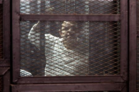 A Muslim Brotherhood supporter convicted of playing a role in the killings of 16 policemen in August 2013 during the upheaval that followed the army's ouster of Islamist president Mohamed Mursi, stands behind bars during their trial in Cairo, February 2, 2015. REUTERS/Mohamed Abd El Ghany