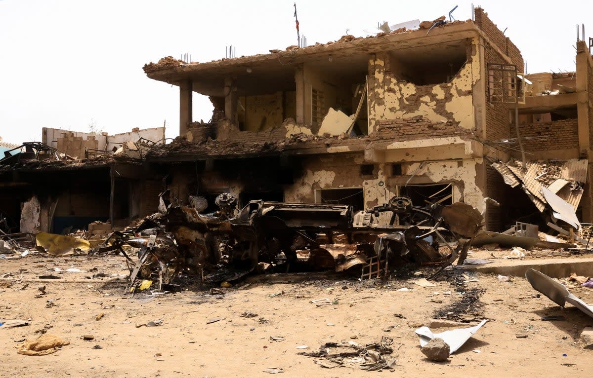 A damaged car and buildings are seen at the central market in Khartoum (REUTERS)