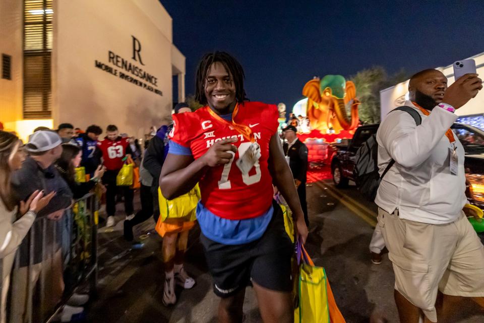 Feb 2, 2024; Mobile, AL, USA; American offensive lineman Patrick Paul of Houston (76) smiles as Senior Bowl football players participate in the Mardi Gras player parade Friday in downtown Mobile. Mandatory Credit: Vasha Hunt-USA TODAY Sports