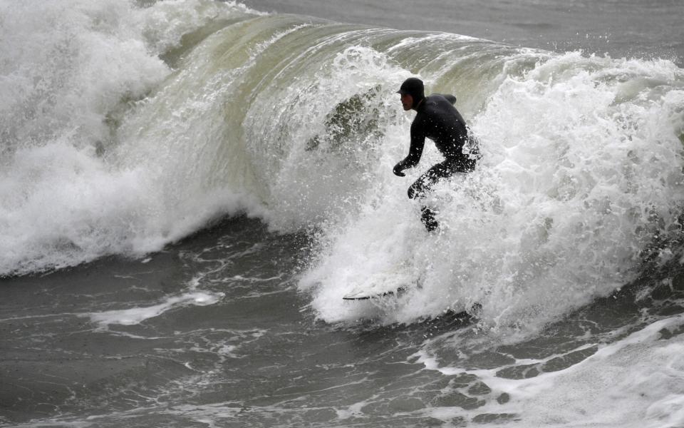 The strong winds proved perfect for surfing in Bournemouth - NEIL HALL/EPA