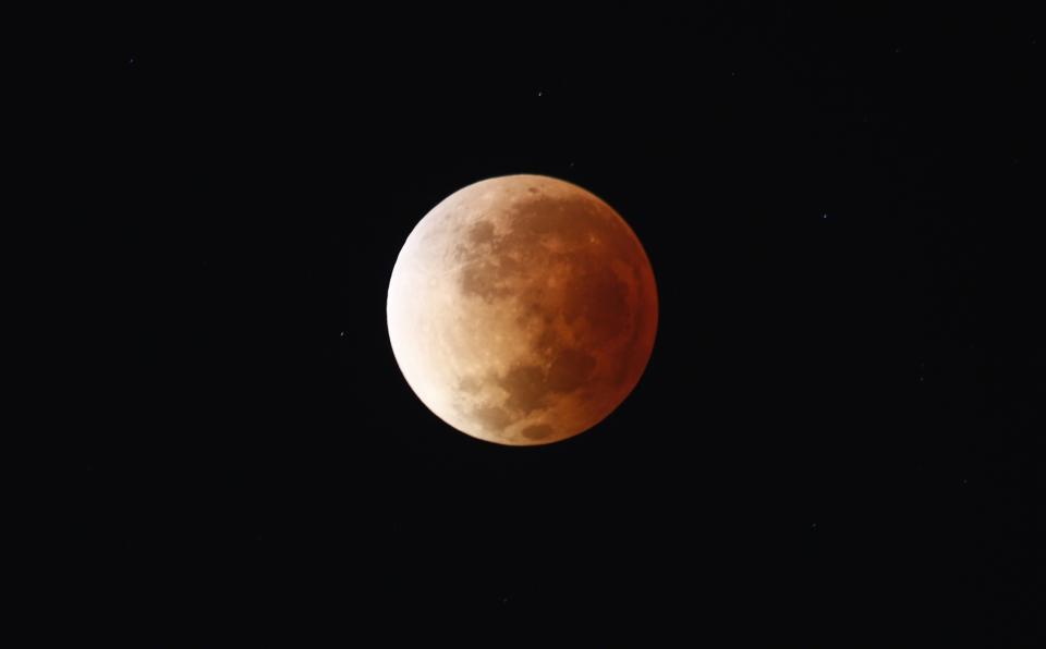 The moon is seen as it begins a total lunar eclipse that will turn the moon red over Buenos Aires April 15, 2014. (REUTERS/Marcos Brindicci)