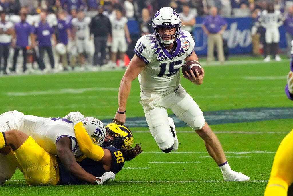 TCU quarterback and former Lewis Central star Max Duggan (15) runs the ball against Michigan during the first half of the Fiesta Bowl NCAA college football semifinal playoff game.