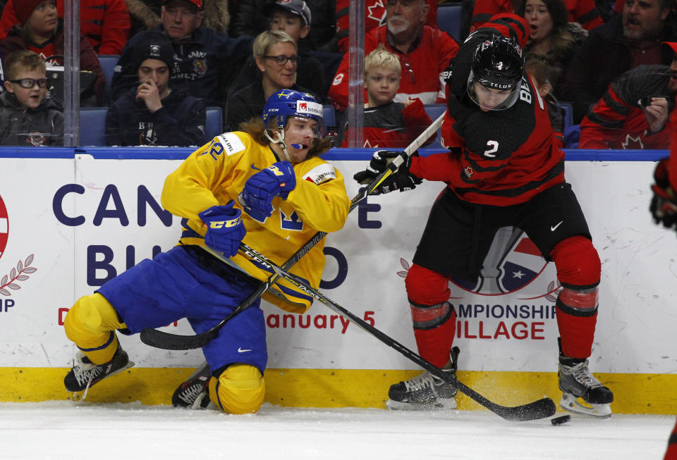 Canada defenseman Jake Bean and Sweden forward Axel Jonsson Fjallby collide during the first period in the gold medal game of the world junior hockey championships, Friday, Jan. 5, 2018 (AP Photo/Jeffrey T. Barnes)
