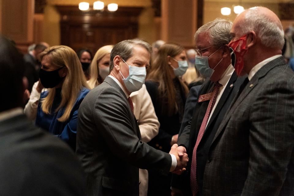 Georgia Gov. Brian Kemp shakes hands with lawmakers ahead of his the 2022 State of the State address. (AP Photo/Brynn Anderson)