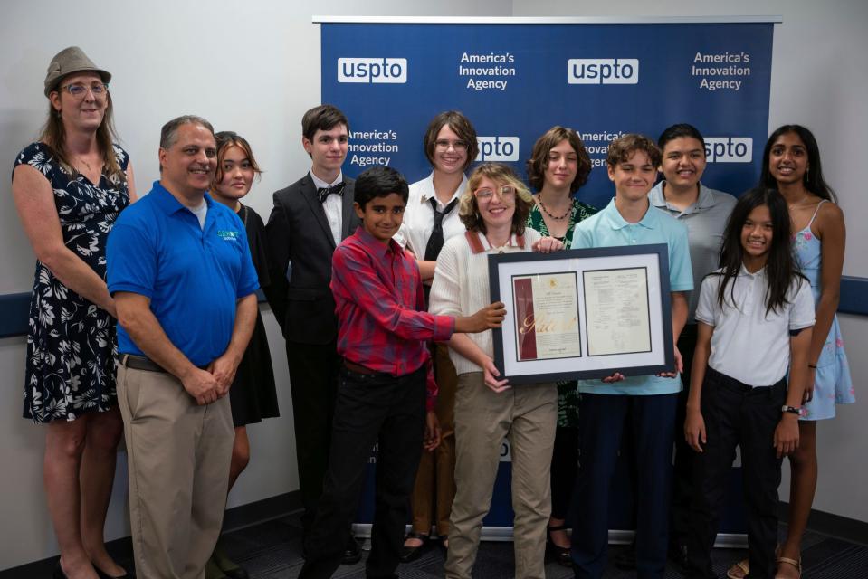 Mentors and student inventors from the Bloomfield Hills school district's GEKOT FIRST LEGO League Robotics Team stand for a photo while being honored by the U.S. Patent and Trade Office for their e-scooter safety device at River Place in Detroit on Tuesday, Aug. 9, 2023.