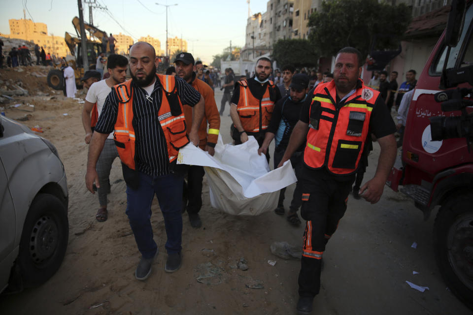 Palestinians carry the body of a child found in the rubble of a house belonging to the Al-Tanani family, that was destroyed in Israeli airstrikes in town of Beit Lahiya, northern Gaza Strip, Thursday, May 13, 2021. (AP Photo/Abdel Kareem Hana)