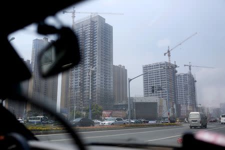 Residential and business buildings are seen under construction in Zhangjiagang, Jiangsu province, China, August 5, 2015. REUTERS/Aly Song/File Photo