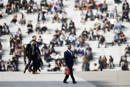 Businessmen enjoy the good weather at lunch time under the Arche de la Defense, in the financial and business district west of Paris, as warm and sunny weather continues in France, March 13, 2014. REUTERS/Charles Platiau