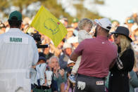 Jon Rahm, of Spain, celebrates with his wife Kelley Cahill and their child on the 18th green after Rahm won the Masters golf tournament at Augusta National Golf Club on Sunday, April 9, 2023, in Augusta, Ga. (AP Photo/Matt Slocum)