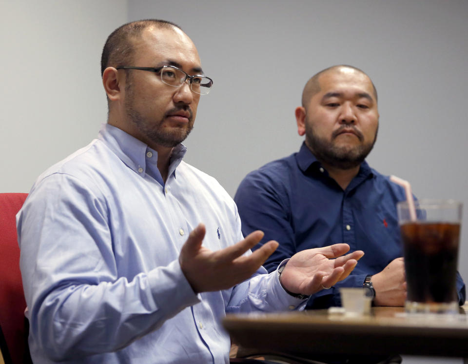 In this Jan. 28, 2019, photo, Kenji Aiba, left, speaks as his partner Ken Kozumi listens during an interview with The Associated Press in Tokyo. Kozumi and Aiba have held onto a marriage certificate they signed at their wedding party in 2013, anticipating that Japan would emulate other advanced nations and legalize same-sex unions. That day has yet to come, and legally they are just friends even though they've lived as a married couple for more than five years. On Thursday, Feb. 14, 2019, Valentine’s Day, the couple is joining a dozen other same-sex couples in Japan’s first lawsuits challenging the constitutionality of the country’s rejection of same-sex marriage. (AP Photo/Toru Takahashi)