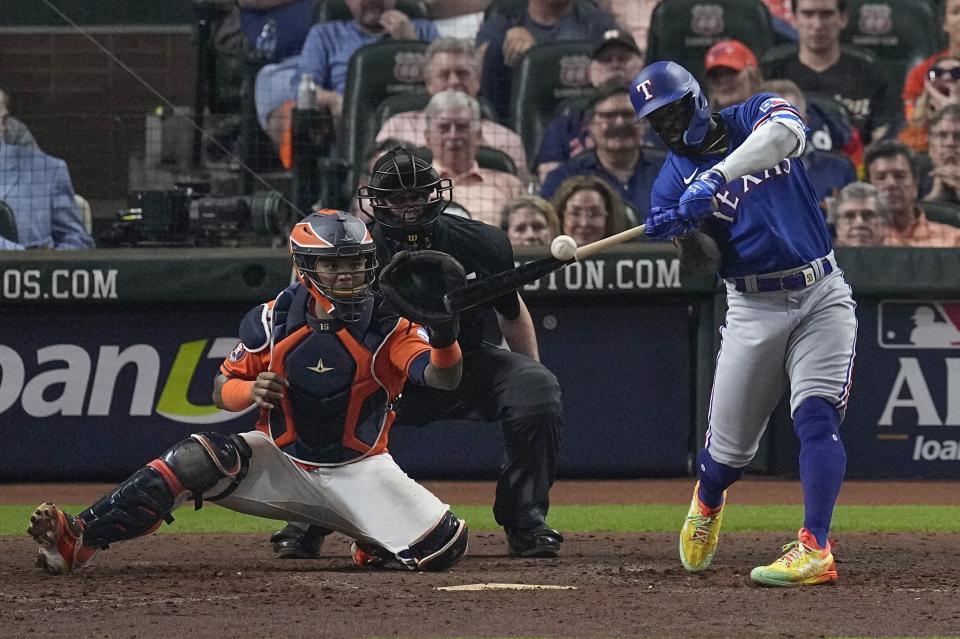 Texas Rangers' Adolis Garcia hits a grand slam during the ninth inning of Game 6 of the baseball AL Championship Series against the Houston Astros Sunday, Oct. 22, 2023, in Houston. (AP Photo/Tony Gutierrez)