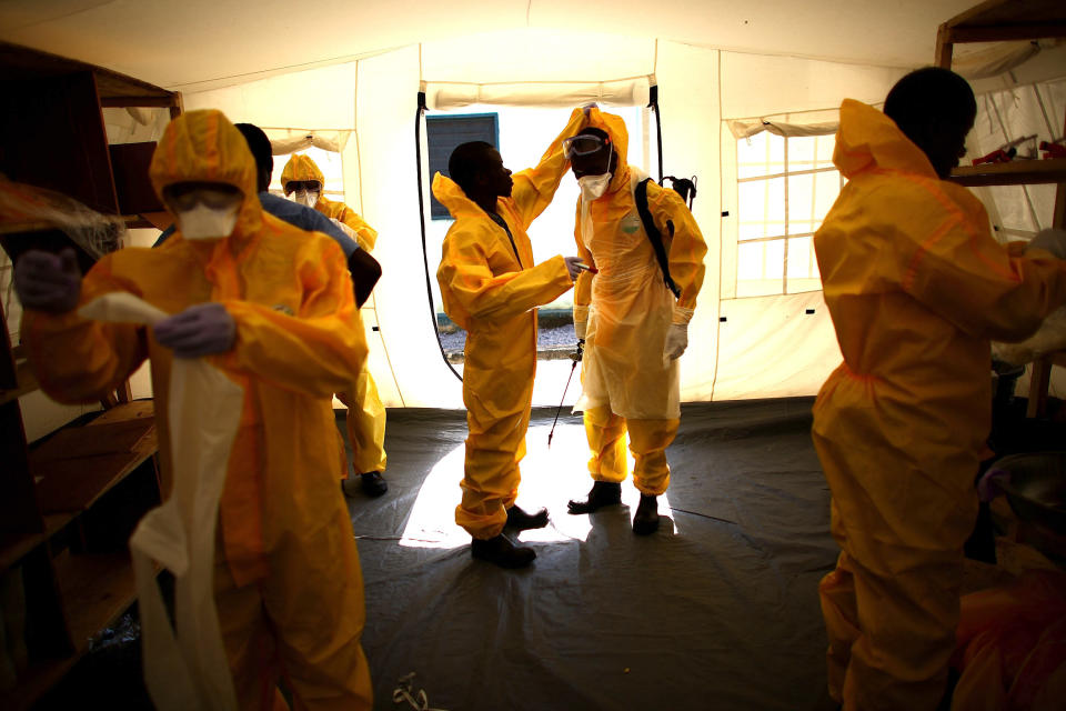 Volunteer workers at a Community Care Center for people suspected of having Ebola in northern Sierra Leone put on&nbsp;their Personal Protective Equipment before entering the compound where the patients are being held.