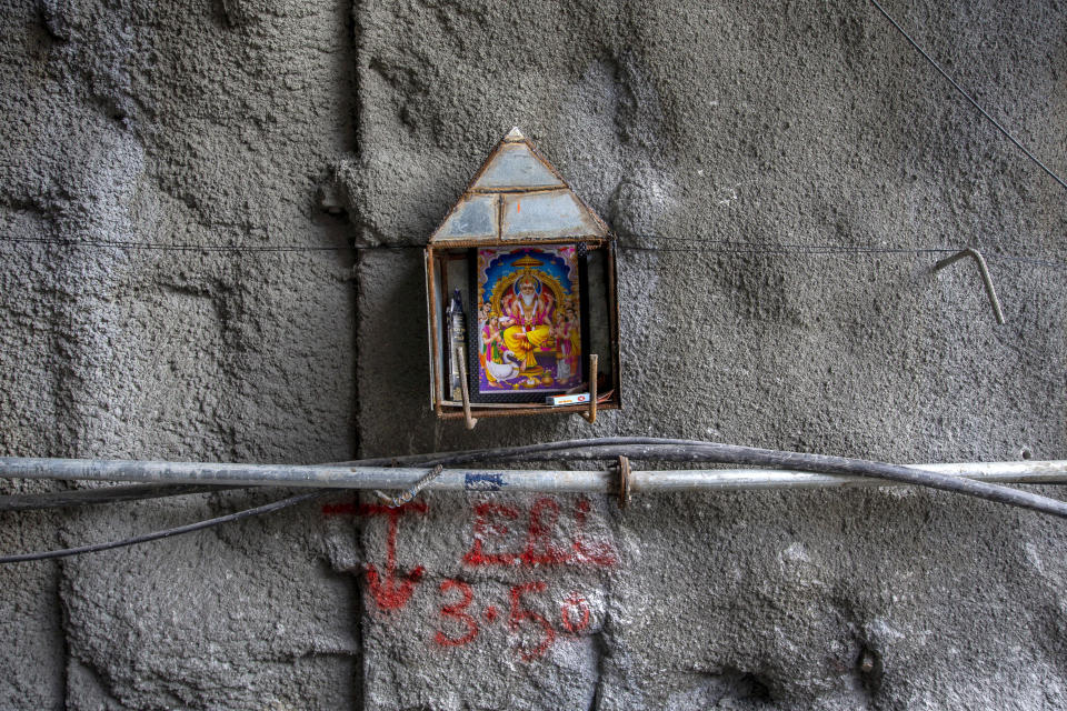 A picture of Hindu craftsman and architect deity Vishwakarma, hangs on a wall of Zojila tunnel in Baltal, northeast of Srinagar, Indian controlled Kashmir, Tuesday, Sept. 28, 2021. High in a rocky Himalayan mountain range, hundreds of people are working on an ambitious project to drill tunnels and construct bridges to connect the Kashmir Valley with Ladakh, a cold-desert region isolated half the year because of massive snowfall. The $932 million project’s last tunnel, about 14 kilometers (9 miles) long, will bypass the challenging Zojila pass and connect Sonamarg with Ladakh. Officials say it will be India’s longest and highest tunnel at 11,500 feet (3,485 meters). (AP Photo/Dar Yasin)