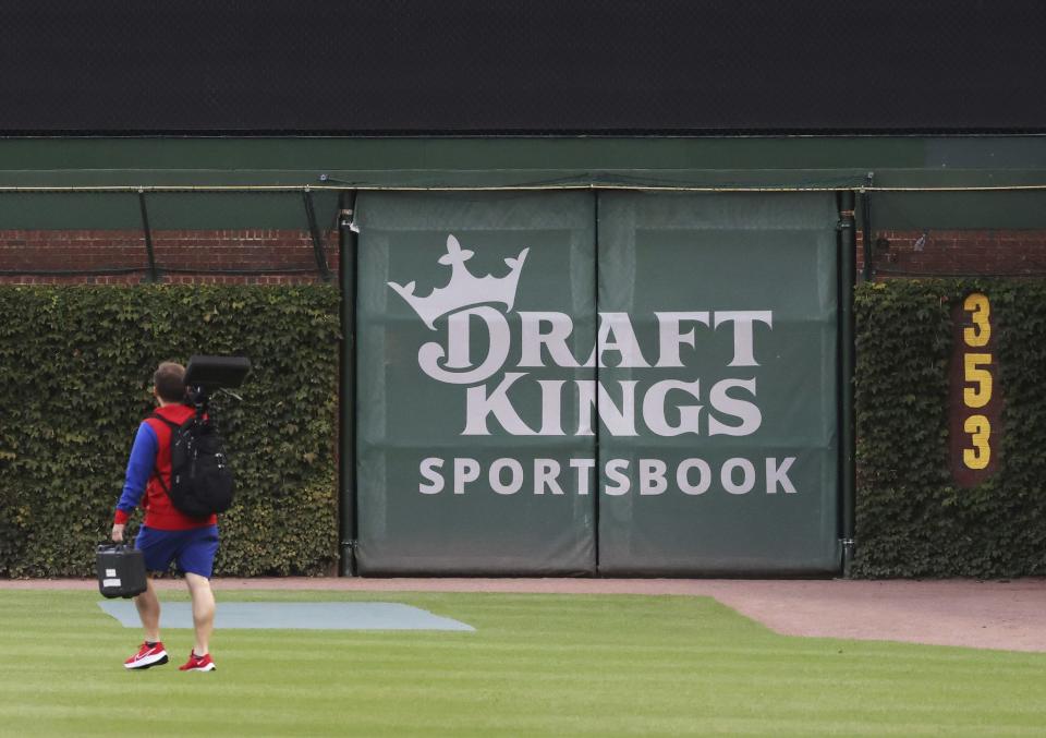 „DraftKings“ sporto lažybų logotipas paskelbtas dešinėje Čikagos „Wrigley Field“ aikštės sienoje prieš 27 m. rugsėjo 2022 d. „Chicago Cubs“ ir „Philadelphia Phillies“ rungtynes. (John J. Kim / Chicago Tribune / Tribune naujienų tarnyba per Getty Images)