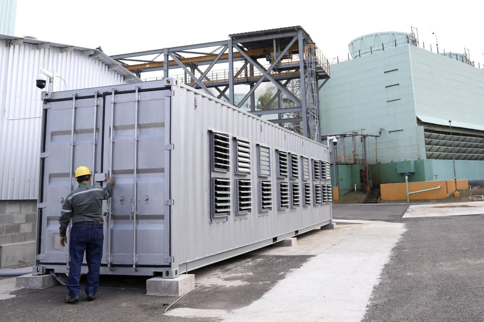 A state worker closes a container holding processors used for bitcoin calculations at the La Geo Geothermal Power Plant in Berlin municipality, Usulutan department, El Salvador, Friday, Oct. 15, 2021. The government announced that it has installed 300 processors at this plant to "mine" cryptocurrency, and is using geothermal resources from the country’s volcanos to run the computers that perform the calculations to verify transactions in bitcoin, recently made legal tender. (AP Photo/Salvador Melendez)