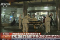 In this Thursday, Jan. 23, 2020, image from China's CCTV video, a patient is carried on a stretcher to an ambulance by medical workers in protective suits in Wuhan, China. China is swiftly building a hospital dedicated to treating patients infected with a new virus that sickened hundreds and prompted unprecedented lockdowns of cities home to millions of people during the country's most important holiday. (CCTV via AP)