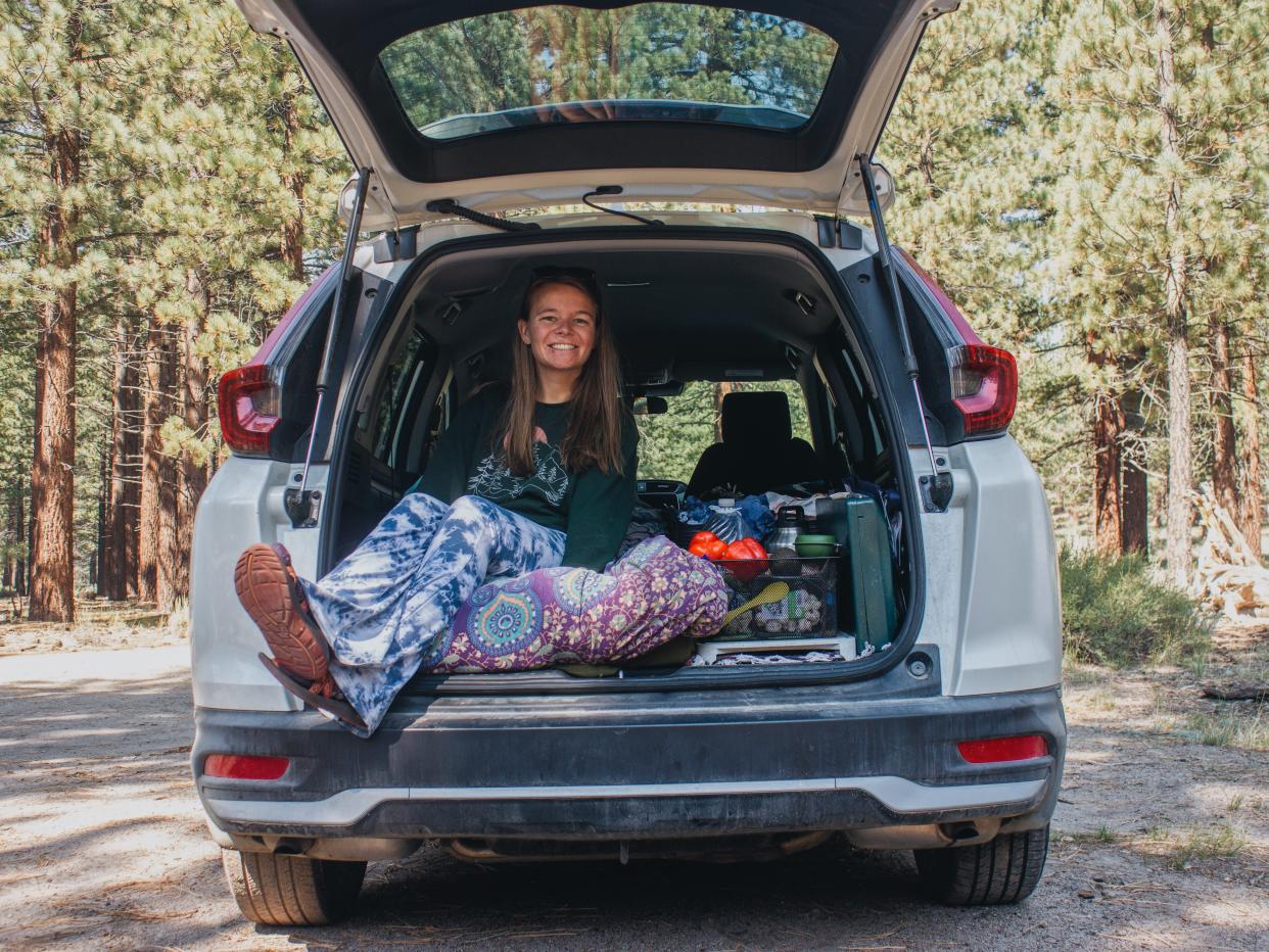 Nicole Jordan sitting in the drunk of her white subaru in a forest